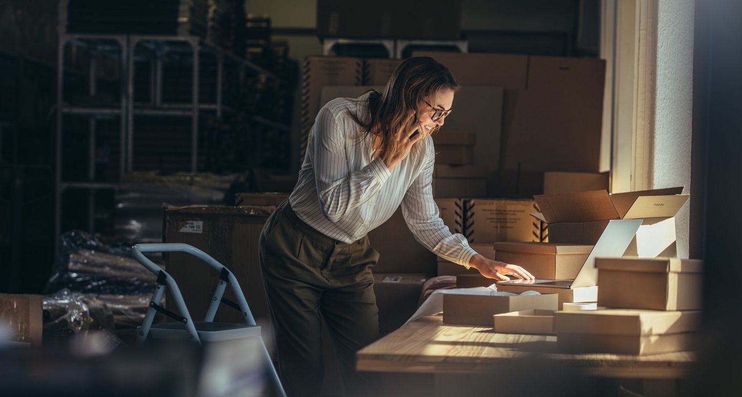 Online store businesswoman working on laptop and taking on the phone. Female business professional taking order on phone.