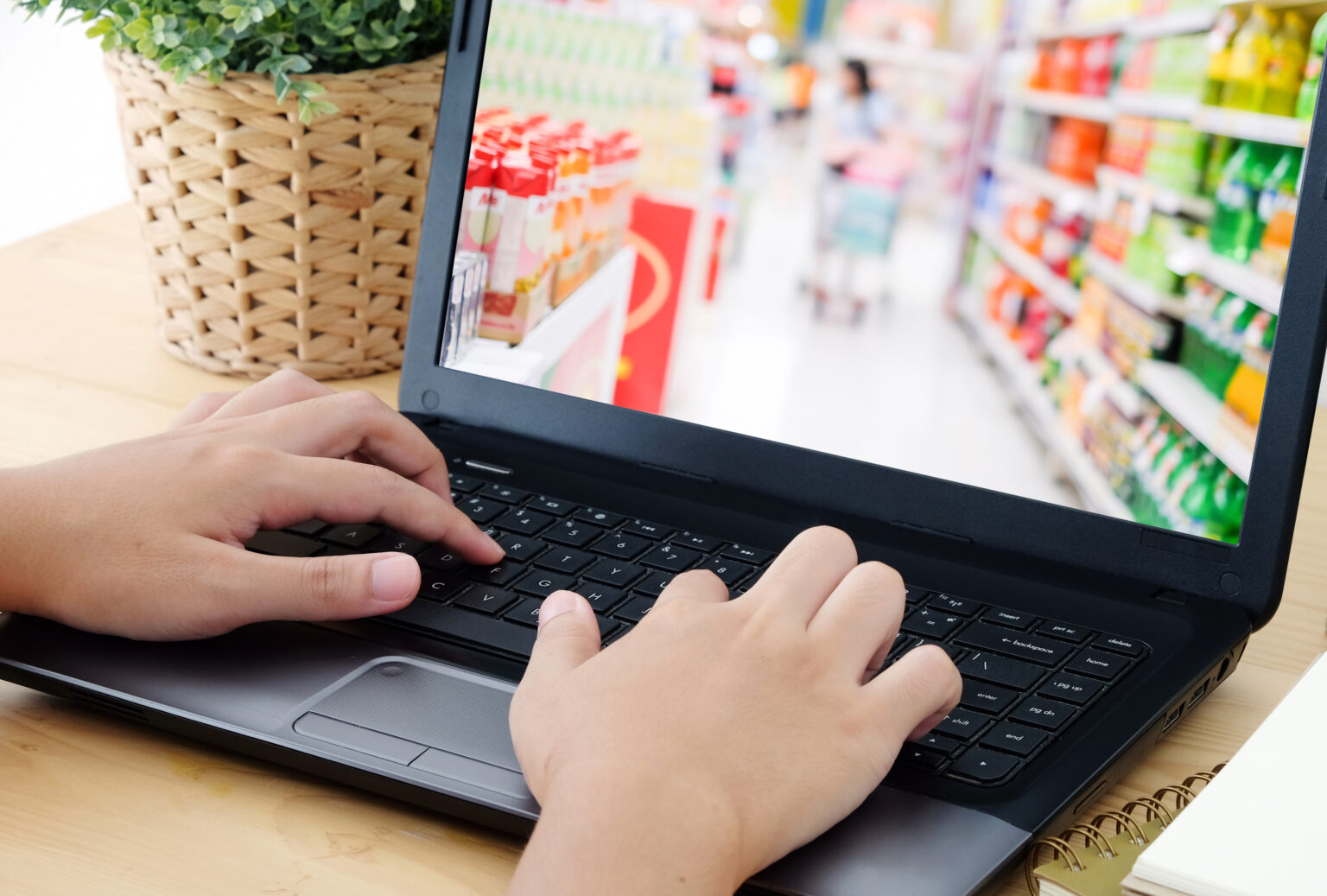 Hand typing laptop with blur supermarket on screen , Grocery online concept, business and technology