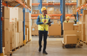 a worker in a warehouse holding a clipboard