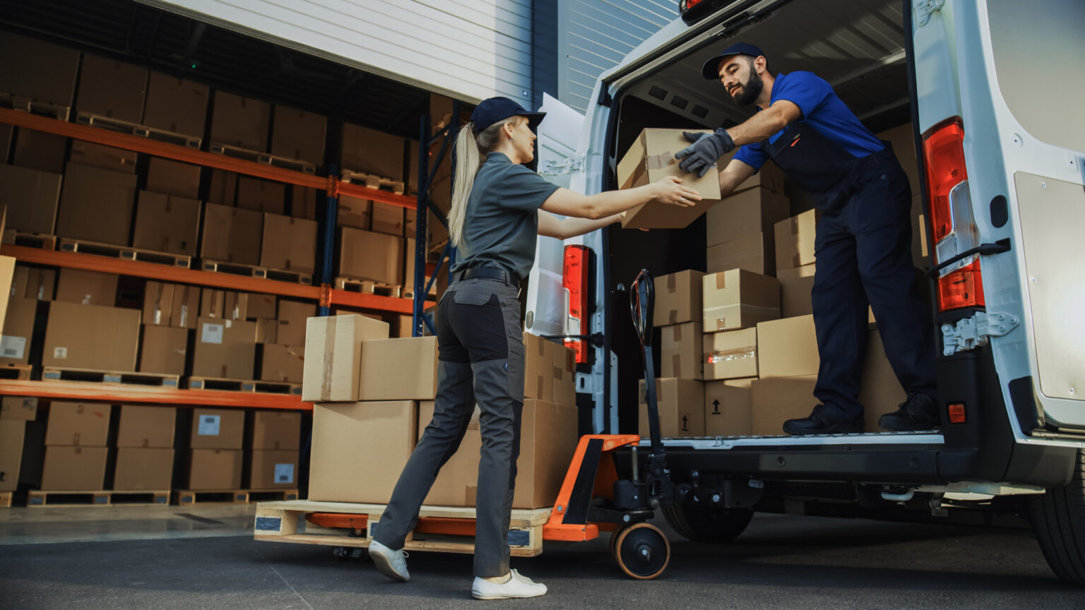 Outside of Logistics Distributions Warehouse: Diverse Team of Workers use Hand Truck Loading Delivery Van with Cardboard Boxes, Online Orders,  E-Commerce Purchases.