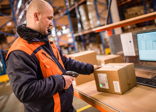 Male worker scanning barcode in warehouse.