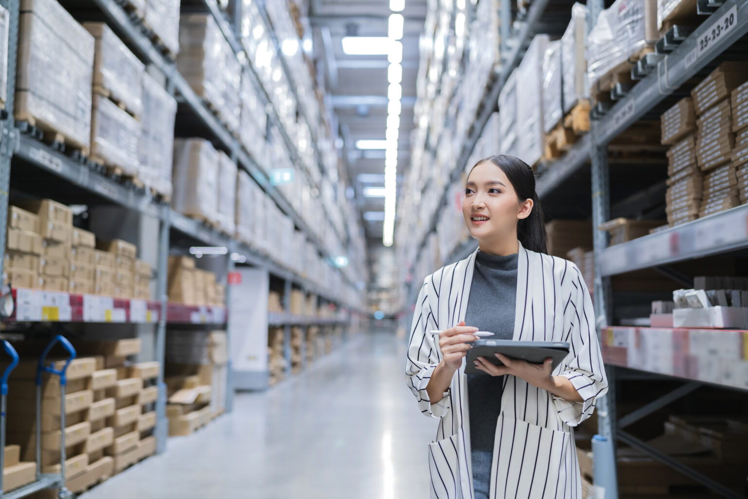 Portrait of asian woman business owner using digital tablet checking amount of stock product inventory on shelf at distribution warehouse factory.logistic business shipping and delivery service Portrait of asian woman business owner using digital tablet checking amount of stock product inventory on shelf at distribution warehouse factory.logistic business shipping and delivery service