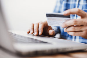 Young man using laptop and credit card. Online shopping concept